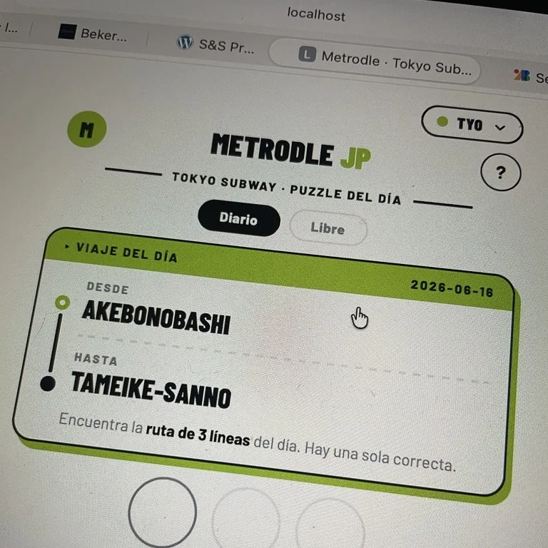 Primer plano en diagonal de la tarjeta del viaje del día en Metrodle JP: de Akebonobashi a Tameike-Sanno, con la instrucción 'Encuentra la ruta de 3 líneas del día' debajo